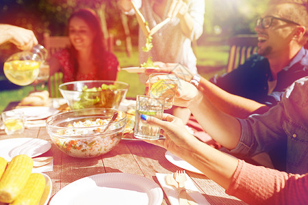 休闲,假期,饮食,人食物的快乐的朋友夏季花园聚会上吃晚饭叮当的饮料快乐的朋友夏天的花园聚会上喝酒背景图片
