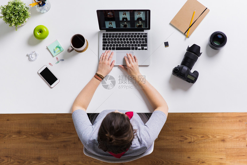 摄影,人技术女人带着相机笔记本电脑上工作桌子上女人带着相机桌上的笔记本电脑上工作图片