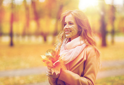 季节人的美丽的轻女人带着枫叶走秋天的公园里秋天公园里枫叶的漂亮女人图片