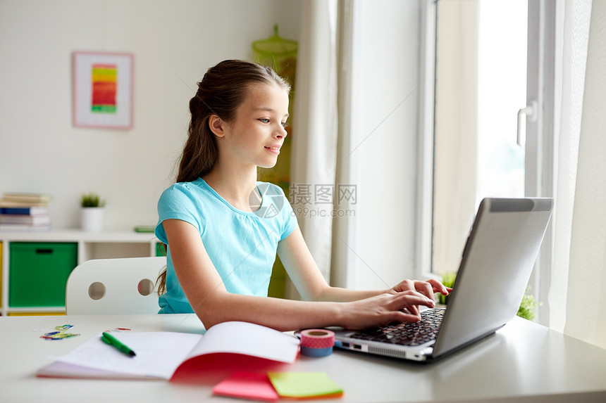 人,孩子,教育学的快乐的女孩笔记本电脑上打字家作业快乐的女孩家用笔记本电脑打字图片