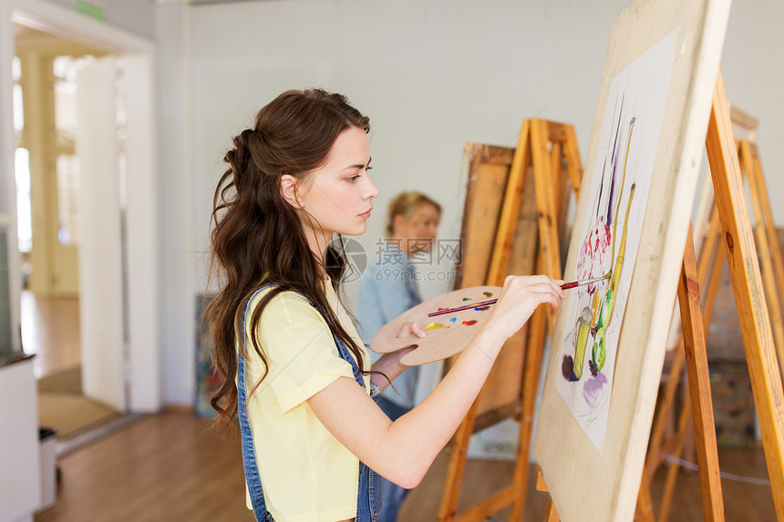 艺术学校,创造力人的学生女孩轻的女艺术家与画架,调色板油漆刷画静物画工作室艺术学校画架的学生女孩图片