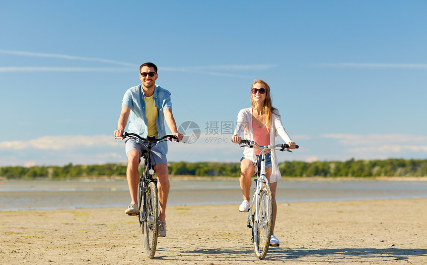 人们,休闲生活方式的快乐的轻夫妇骑自行车海滩上快乐的轻夫妇海边骑自行车图片