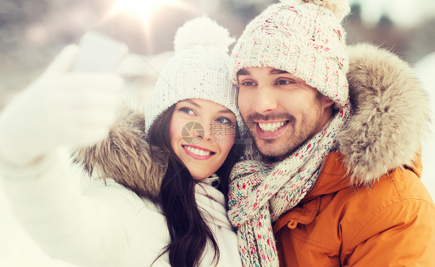 人们,季节,爱情,技术休闲快乐的夫妇冬天的背景下用智能手机自拍快乐的夫妇冬天用智能手机自拍图片