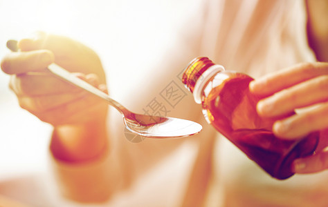医疗保健,人医学妇女倒药退热糖浆瓶匙女人把药物瓶子里灌勺子里图片
