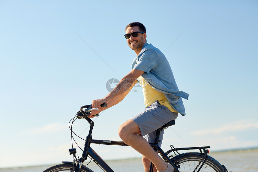 人们,休闲生活方式的快乐的轻人骑自行车沿夏海滩快乐的人骑自行车沿着夏天的海滩图片