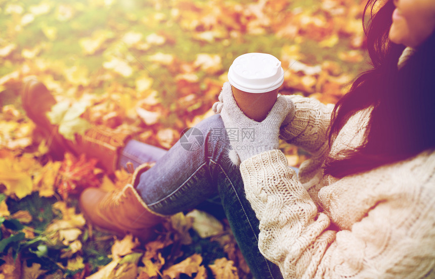 季节,技术人的接近快乐的轻女人喝咖啡纸杯秋季公园秋天的公园里亲密的女人喝咖啡图片