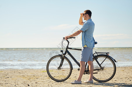 人,休闲生活方式的快乐的轻人骑自行车海滩上快乐的轻人海滩上骑自行车图片