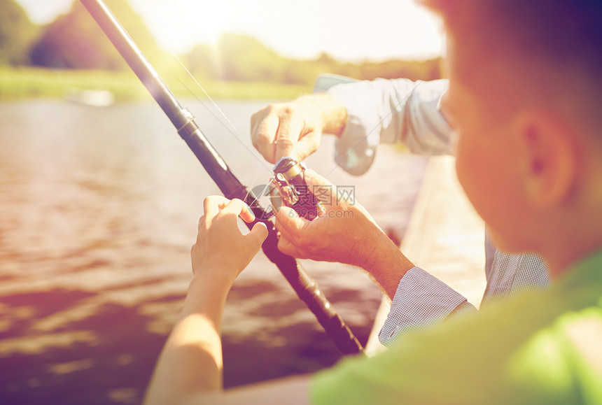 家庭,世代,暑假人的男孩祖父与鱼竿河流湖泊泊位男孩祖父河里钓鱼图片