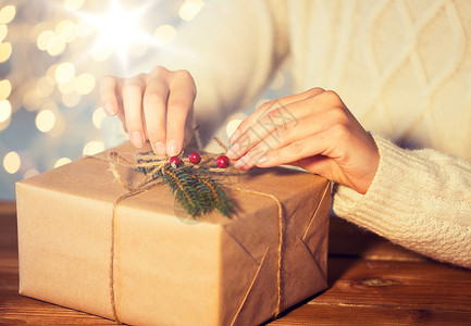 有装饰信纸诞节,假日,礼物,新人们的妇女装饰礼品盒包裹成棕色的信纸与冷杉早午餐用诞礼物包裹靠近女人背景