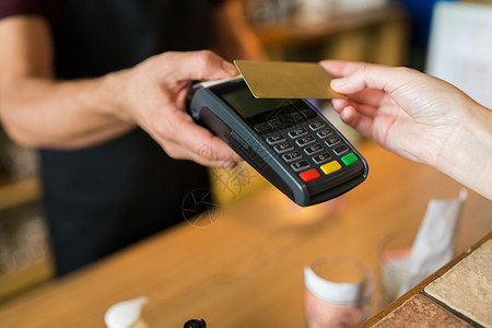 销售时点情报系统现代技术人的男人酒保与支付终端客户的手与信用卡咖啡厅酒吧手支付终端信用卡背景