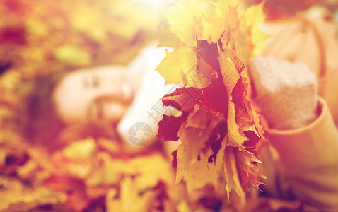 季节人的特写美丽的轻女人秋天枫叶躺地上靠近躺秋叶上的快乐女人背景