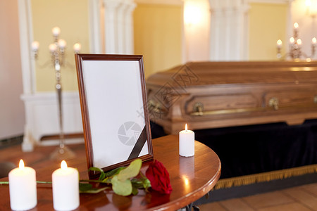 葬礼哀悼相框与黑色丝带,燃烧蜡烛棺材教堂教堂葬礼上的相框棺材背景