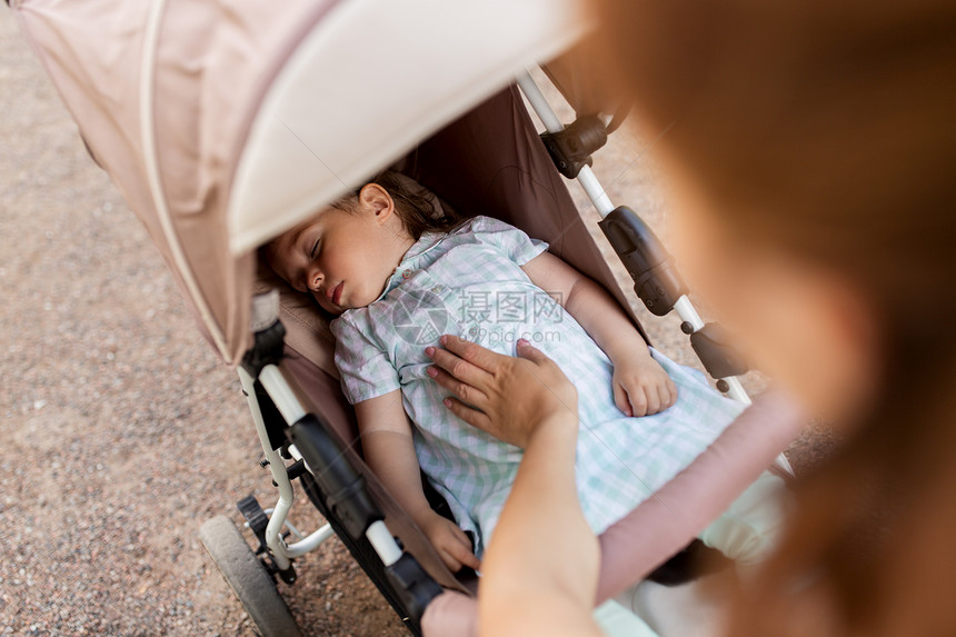 家庭母亲人的母亲带着孩子睡婴儿车里母亲带着孩子睡婴儿车里图片