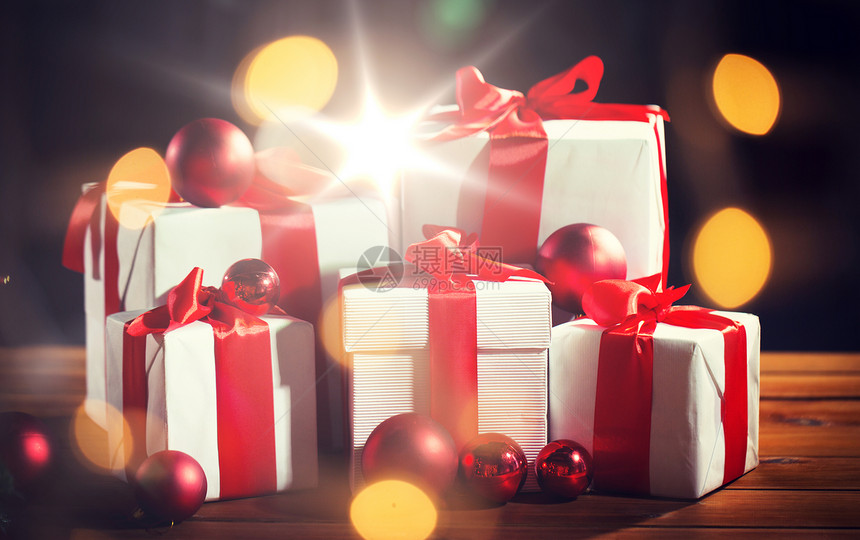 诞节,假日,礼物,新庆祝礼品盒红球木地板上的灯光背景木地板上的礼品盒红色诞球图片