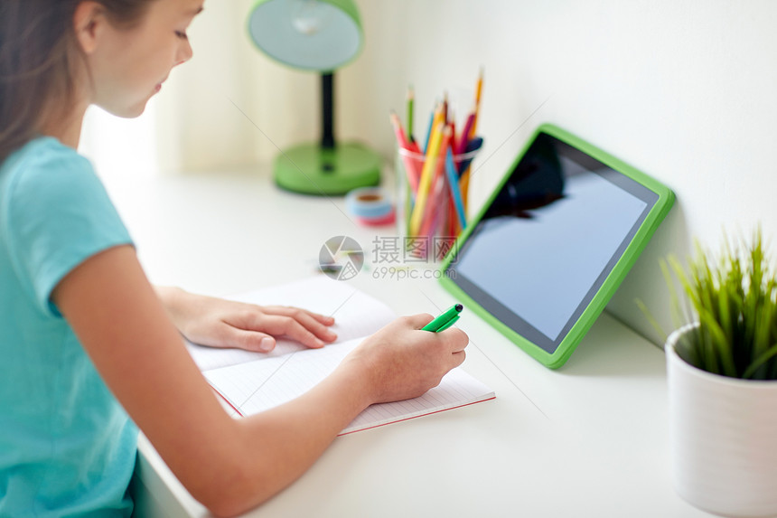 人孩子教育理念快乐的女孩用平板电脑家里写笔记本女孩家里用平板电脑写笔记本图片