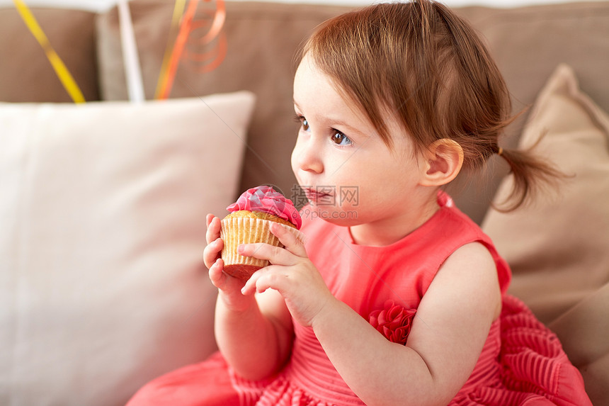 童,假期人们的快乐的女婴家里的生日聚会上吃纸杯蛋糕生日派上快乐的女婴吃纸杯蛋糕图片