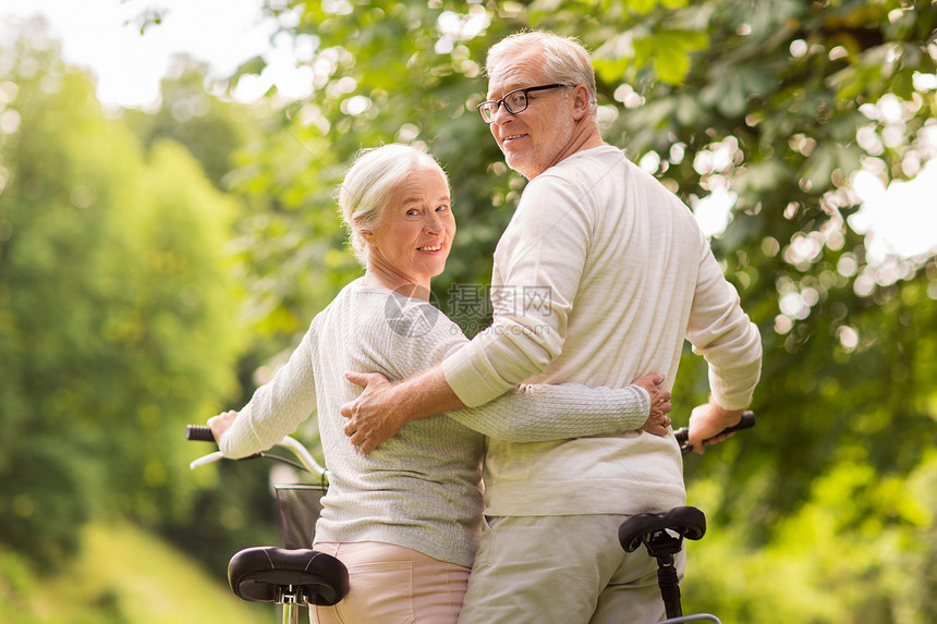 老,人生活方式的快乐的老夫妇与自行车拥抱夏季城市公园快乐的老夫妇夏季公园骑自行车图片