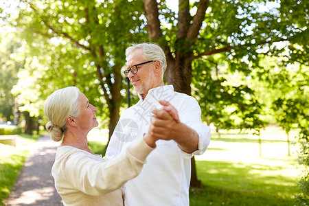 老,关系人的快乐的老夫妇夏季城市公园跳华尔兹快乐的老夫妇夏季城市公园跳舞背景图片