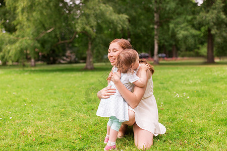 家庭,童父母的快乐的母亲拥抱小女婴夏季公园快乐的母亲夏天的公园拥抱女婴图片