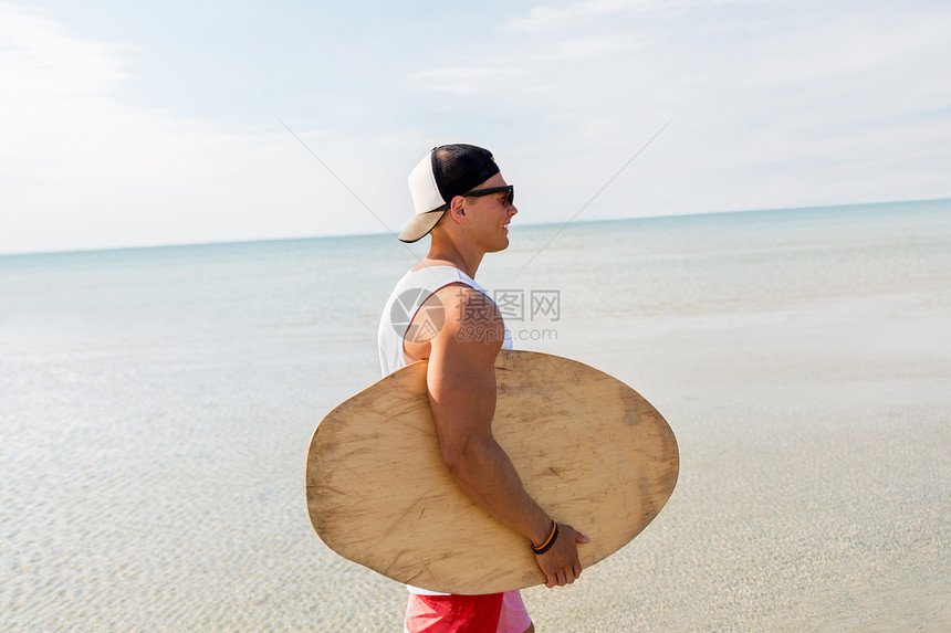 脱脂,水上运动人们的快乐的微笑轻人与脱脂板夏季海滩快乐的轻人夏天的海滩上玩脱脂板图片