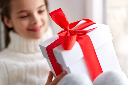 青少前礼物童,假期人的快乐的美丽女孩与诞礼物坐窗台家里的窗户带着诞礼物的女孩坐家里的窗台上背景