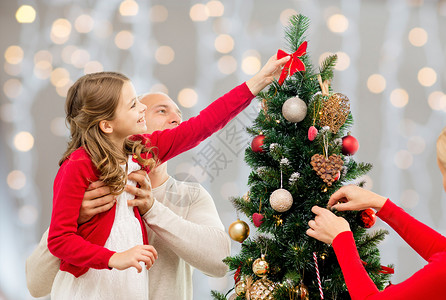家庭,假期人的快乐的母亲,父亲女儿灯光背景下装饰诞树诞树上的母亲父亲女儿图片