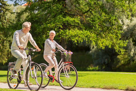 积极的老,人生活方式的快乐的老夫妇骑自行车夏季公园快乐的老夫妇夏季公园骑自行车背景图片
