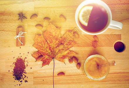 秋季民族科学柠檬茶蜂蜜木板上与枫叶杏仁木板上的柠檬茶蜂蜜图片