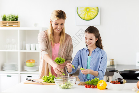 母亲做的饭健康饮食,家庭人的快乐的母亲女儿家里厨房饭蔬菜沙拉快乐的家庭烹饪沙拉家厨房背景