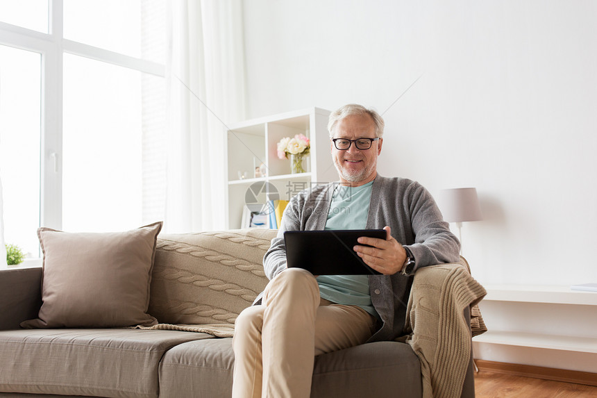 技术,老,人生活方式的快乐的微笑老人与平板电脑电脑坐沙发上家老人与平板电脑坐沙发上家图片