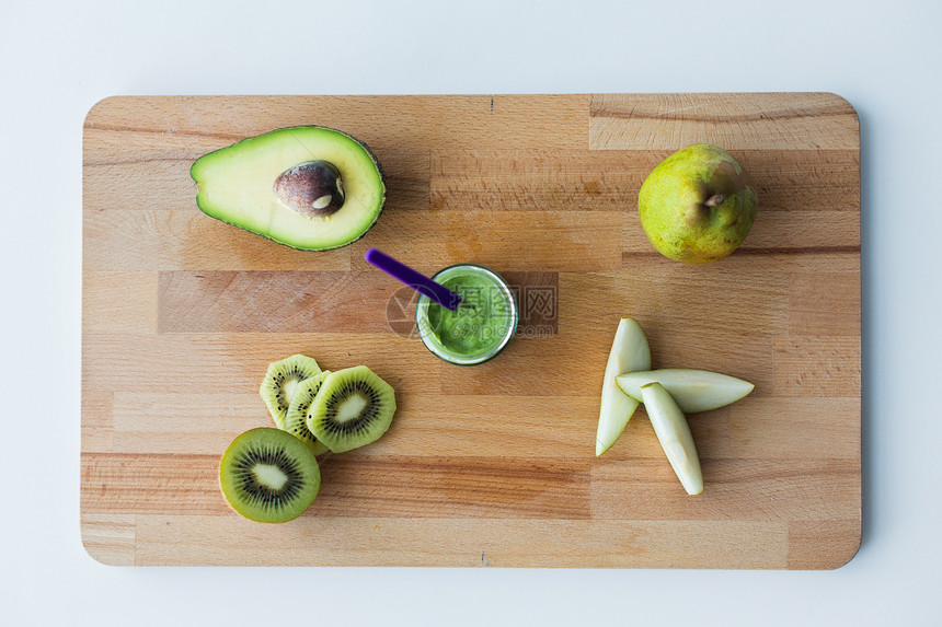 婴儿食品,健康饮食营养璃罐与绿色水果泥木制切割板木板上装水果酱婴儿食品的罐子图片