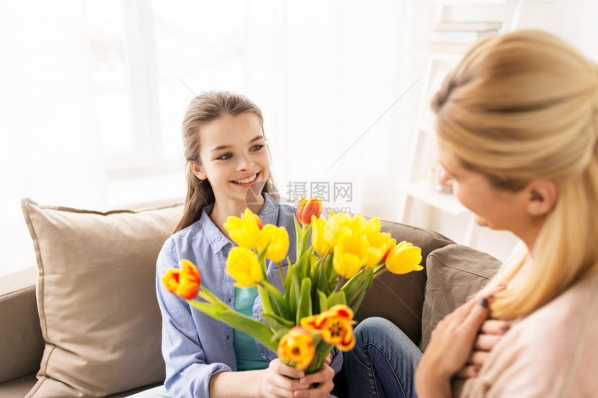 人,家庭假期的快乐的女孩给她的母亲家郁金香花快乐的女孩家里给妈妈送花图片