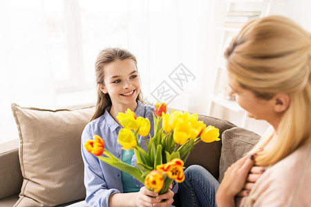 人,家庭假期的快乐的女孩给她的母亲家郁金香花快乐的女孩家里给妈妈送花图片