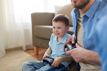 家庭,父亲人的快乐的父亲小儿子与游戏垫家里玩电子游戏父子家里玩电子游戏图片