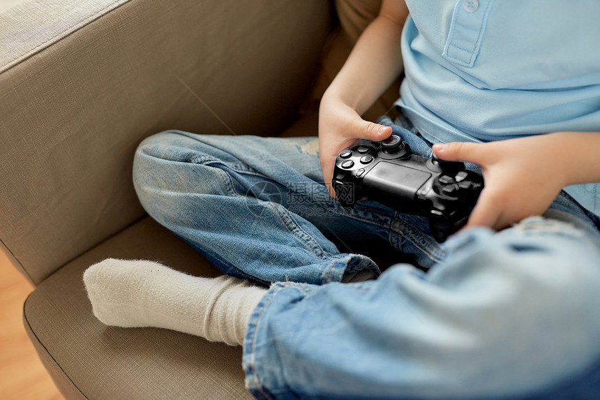 休闲,儿童,技术人的小男孩与游戏垫家里玩电子游戏小男孩带着游戏垫家玩电子游戏图片