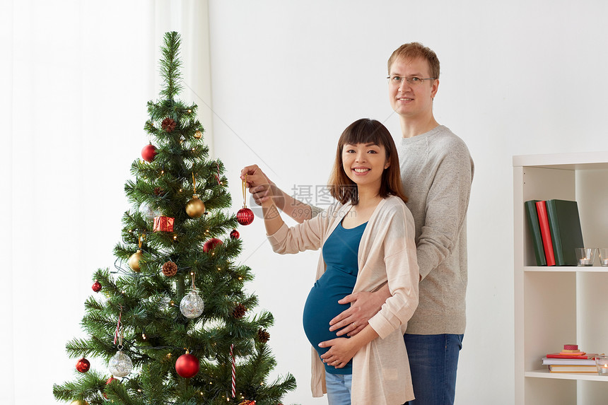 怀孕,寒假人们的幸福的夫妇家里装饰诞树快乐的怀孕妻子丈夫诞树上图片