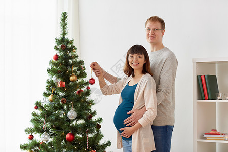 怀孕,寒假人们的幸福的夫妇家里装饰诞树快乐的怀孕妻子丈夫诞树上图片