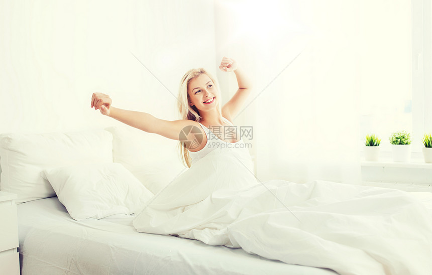 休息,睡觉,舒适人的轻的女人床上伸展家里的卧室轻的女人家里的卧室里躺床上图片