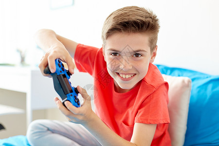 游戏,技术人的微笑男孩与游戏垫家里玩电子游戏快乐的男孩家里玩电子游戏图片