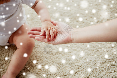 家庭,慈善人的亲密的小婴儿母亲的手雪把小宝宝妈妈的手关来背景图片