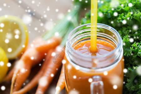 健康的饮食,饮食素食的璃罐杯子与胡萝卜汁稻草覆盖雪用胡萝卜汁璃罐杯子图片