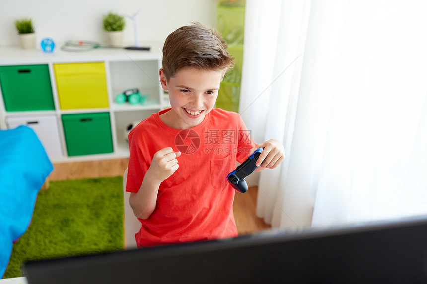 游戏,技术人的微笑男孩与游戏电脑玩电子游戏,并庆祝胜利家里电脑上玩电子游戏的游戏玩家男孩图片
