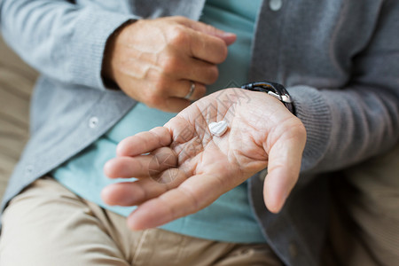 医学,医疗人的密切老人的手与心形药丸用心形药丸把老人的手收来图片