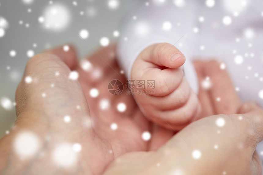 家庭,母亲,人儿童保育的密切母亲新生儿的手雪上母亲新生婴儿的手图片