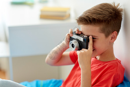 爱好,技术人的快乐的男孩与电影相机拍摄家快乐的男孩家里用胶卷照相图片