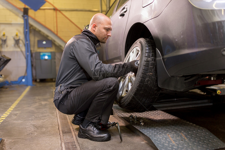 汽车服务,维修,维护人的汽车机械师更换轮胎车间汽车机械师车间更换汽车轮胎图片