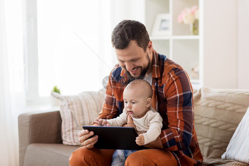 家庭,父母人的快乐的父亲小男孩与平板电脑电脑家里快乐的父亲男孩家里用平板电脑图片