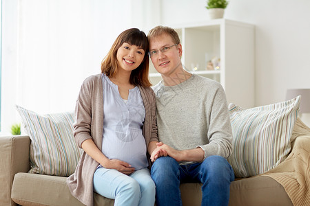 怀孕,家庭人的幸福的怀孕妻子丈夫坐沙发上家幸福的怀孕妻子丈夫家图片