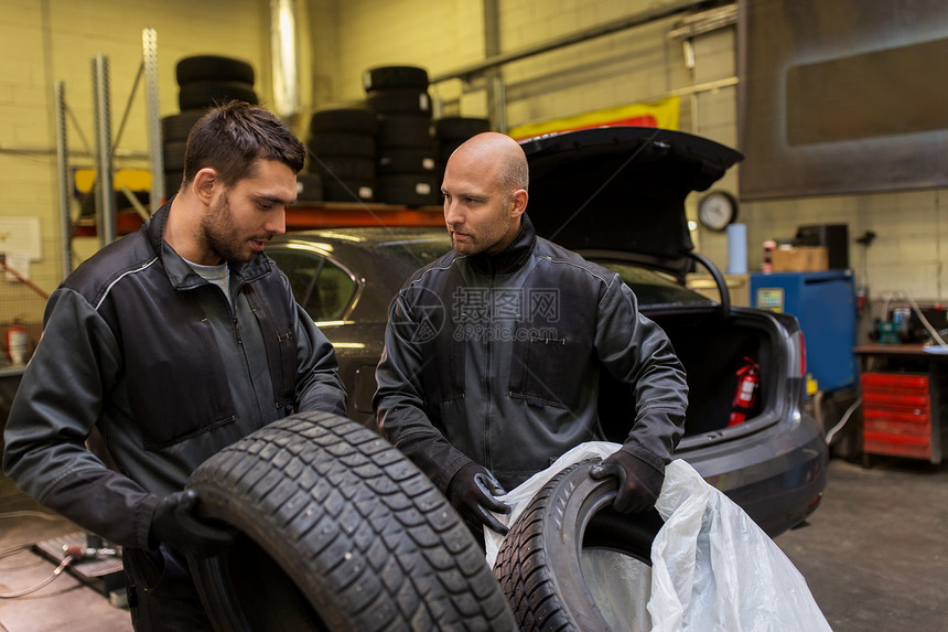 汽车服务,维修,维护人的两个汽车机械更换轮胎车间汽车机械师车间更换汽车轮胎图片