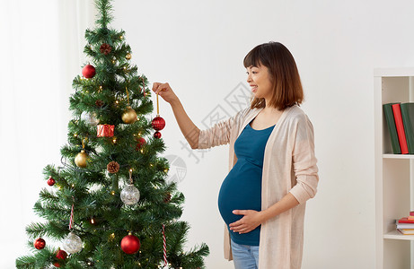 怀孕,寒假人们的怀孕的亚洲妇女家里装饰诞树孕妇家装饰诞树图片
